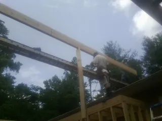 Carpenter setting a ridge beam over a new addition frame — Ice Dam Removal by Roofing Brothers in Monkton