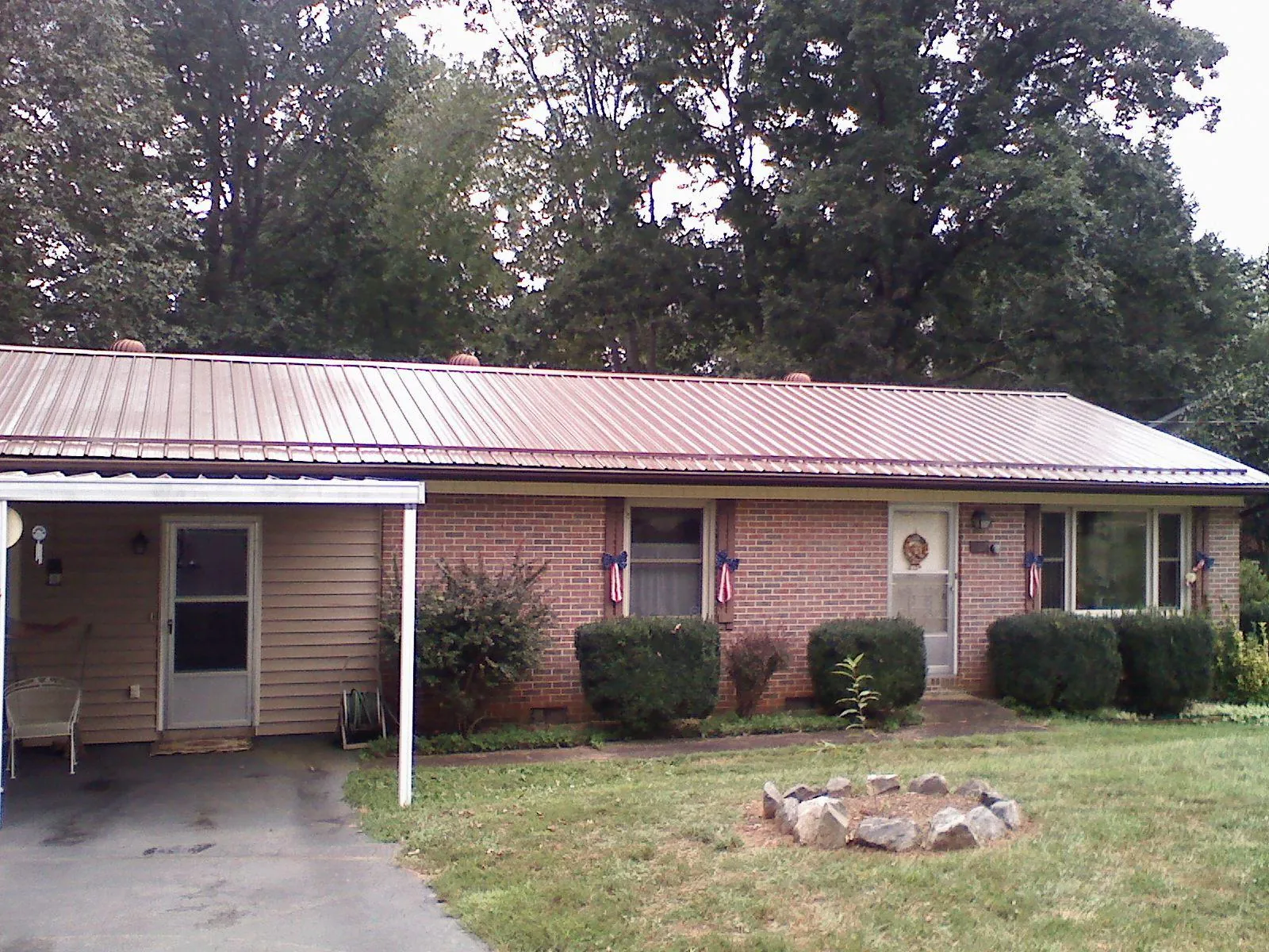 Bronze metal roof and carport on a brick ranch home — Roof Repair work by our crew in Monkton